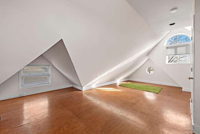 bonus room with hardwood / wood-style flooring and vaulted ceiling