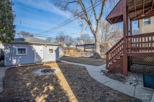 view of yard with a pergola, an outbuilding, and a deck