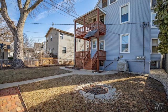 rear view of house with a balcony and a fire pit