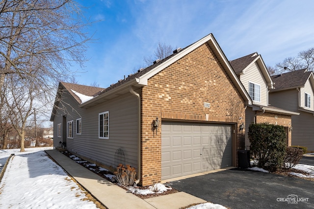 view of snowy exterior with a garage, central AC unit, aphalt driveway, and brick siding