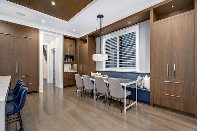 interior space featuring baseboards, a tray ceiling, dark wood finished floors, and recessed lighting