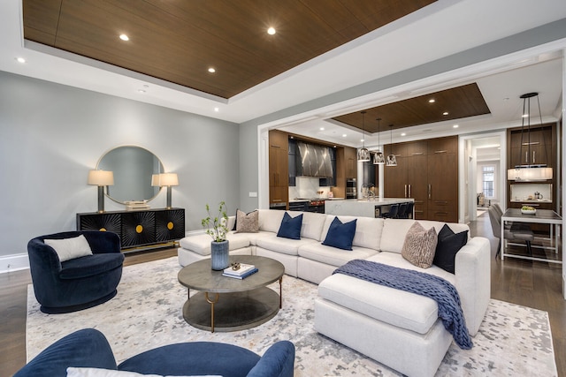 living area featuring dark wood-style floors, a tray ceiling, wood ceiling, and baseboards