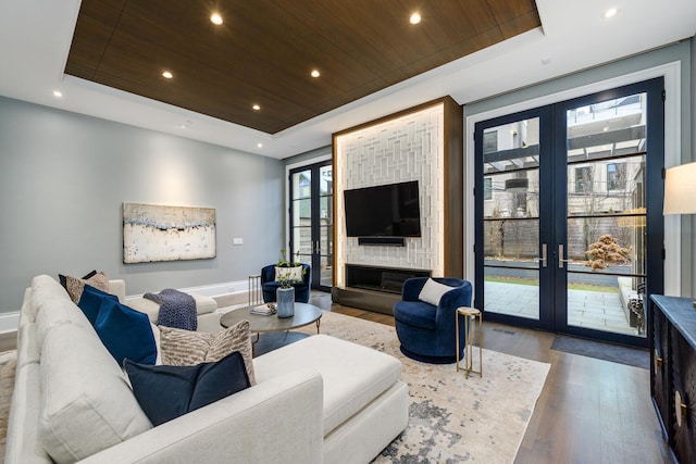 living area with french doors and a tray ceiling