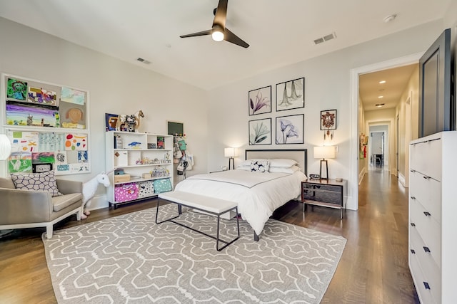 bedroom with baseboards, wood finished floors, visible vents, and a ceiling fan