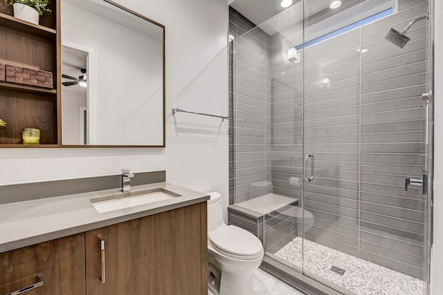 bathroom featuring toilet, a shower stall, ceiling fan, and vanity