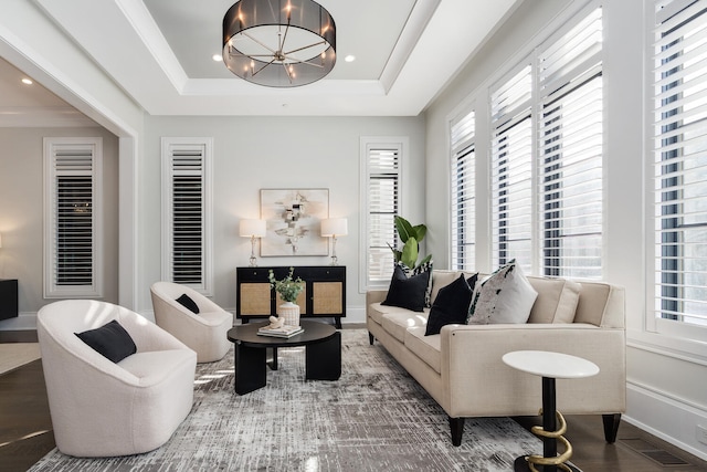 living area with baseboards, a raised ceiling, wood finished floors, a chandelier, and recessed lighting