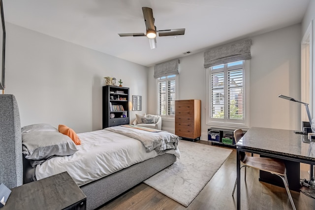 bedroom with visible vents, ceiling fan, and wood finished floors