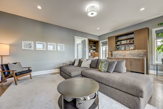 living area with light wood-style floors, baseboards, and recessed lighting