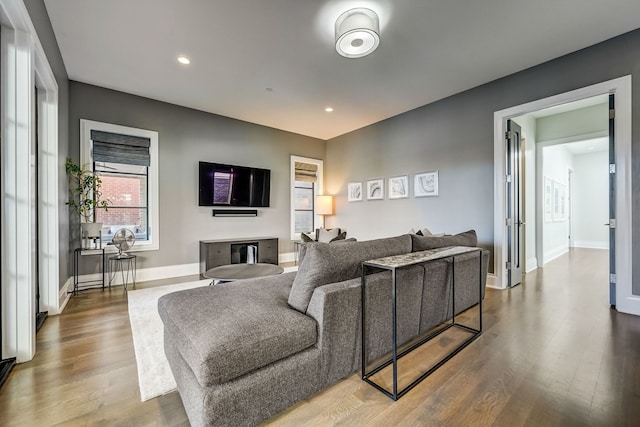 living room with baseboards, wood finished floors, and recessed lighting