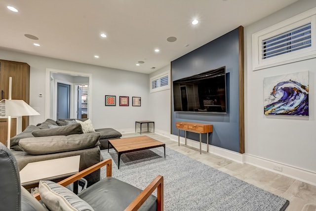 living area with baseboards, light wood-type flooring, and recessed lighting