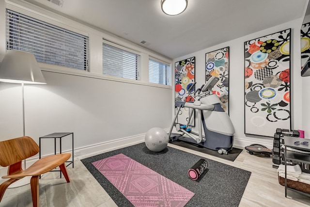 exercise area featuring baseboards and wood finished floors