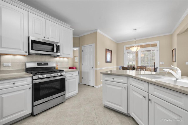 kitchen featuring a sink, appliances with stainless steel finishes, crown molding, white cabinetry, and decorative backsplash