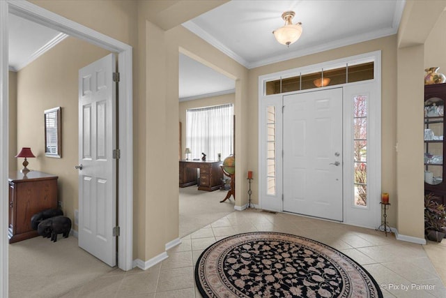 entryway with light tile patterned floors, light colored carpet, baseboards, and crown molding