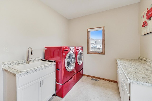 clothes washing area featuring cabinets, independent washer and dryer, light tile patterned floors, and sink