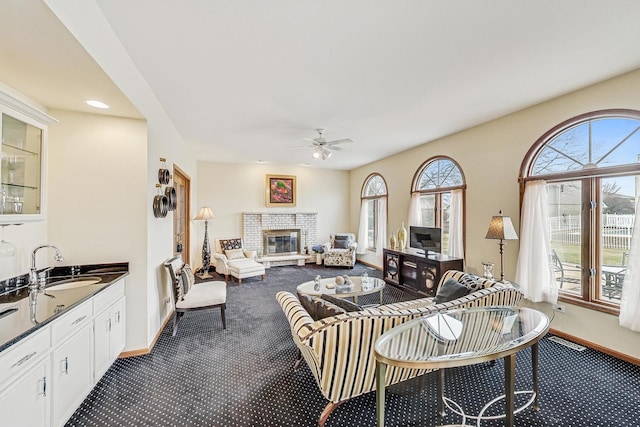 living room featuring sink, carpet flooring, and ceiling fan