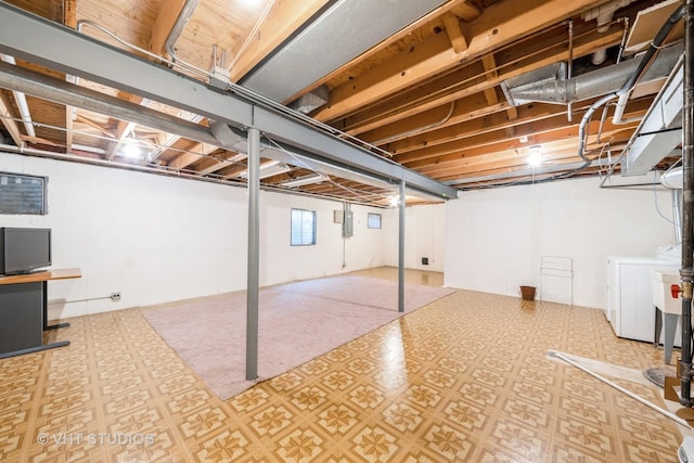 below grade area with washing machine and dryer and tile patterned floors