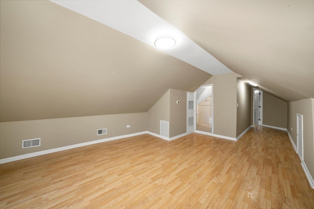 additional living space with light wood finished floors, baseboards, and visible vents