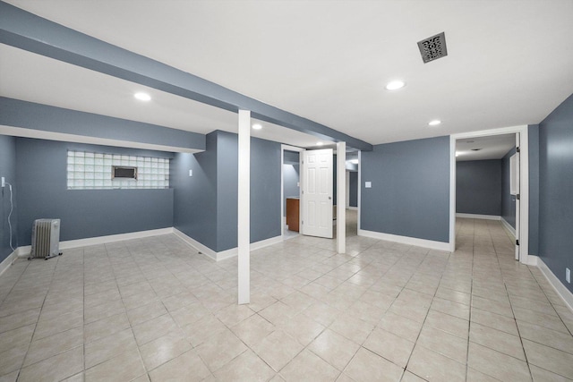 basement featuring recessed lighting, baseboards, visible vents, and radiator heating unit