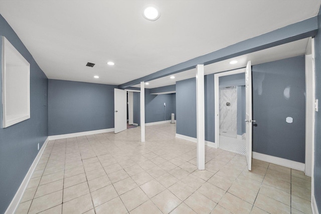 finished below grade area featuring recessed lighting, visible vents, baseboards, and light tile patterned flooring