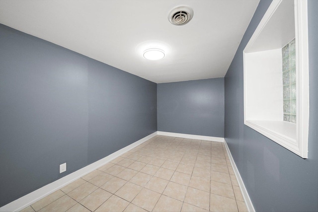 spare room featuring light tile patterned floors, baseboards, and visible vents