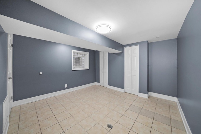 empty room with light tile patterned floors and baseboards