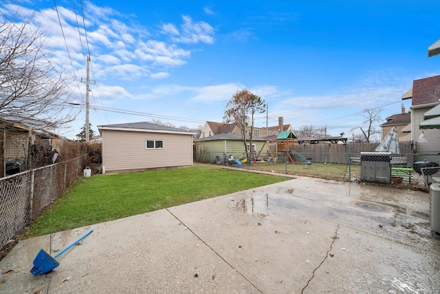 back of property with a lawn, a fenced backyard, an outbuilding, a patio area, and a playground