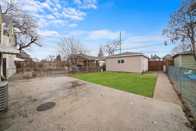 view of yard featuring an outbuilding, a patio area, and a fenced backyard