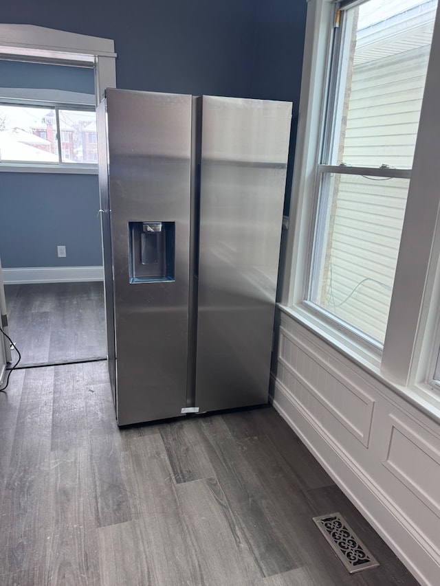 kitchen with baseboards, visible vents, stainless steel refrigerator with ice dispenser, and wood finished floors