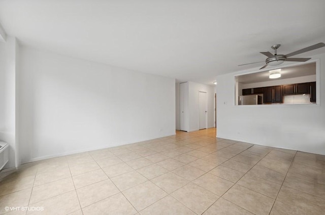 tiled empty room featuring ceiling fan