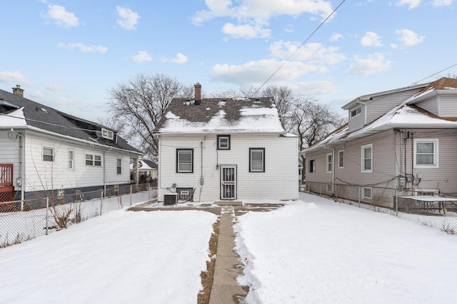 snow covered rear of property with central AC unit