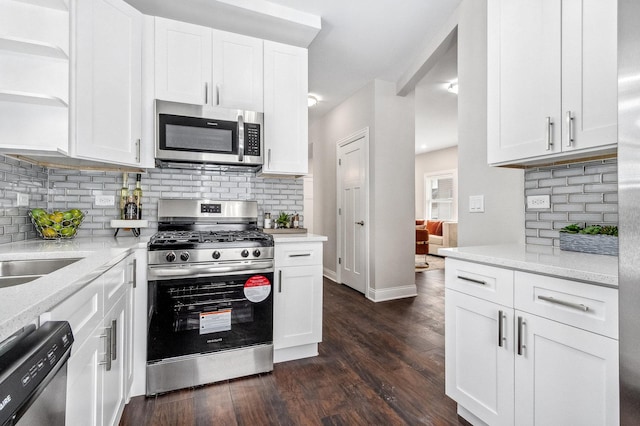 kitchen featuring stainless steel appliances, light stone counters, tasteful backsplash, white cabinets, and dark hardwood / wood-style flooring