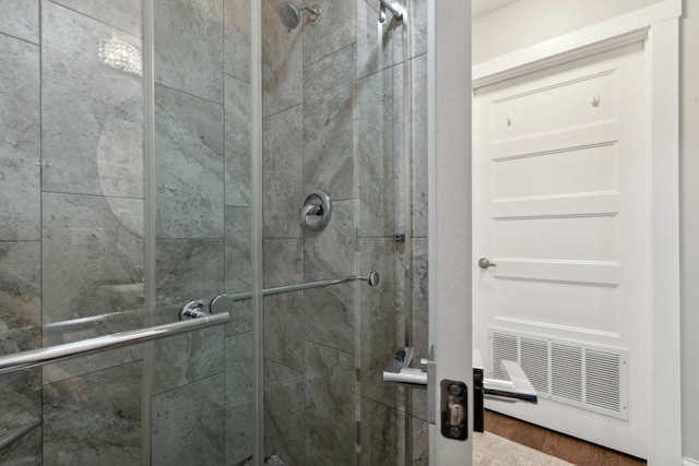 bathroom featuring hardwood / wood-style flooring and a shower with door