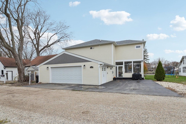 view of side of property with a garage and a trampoline