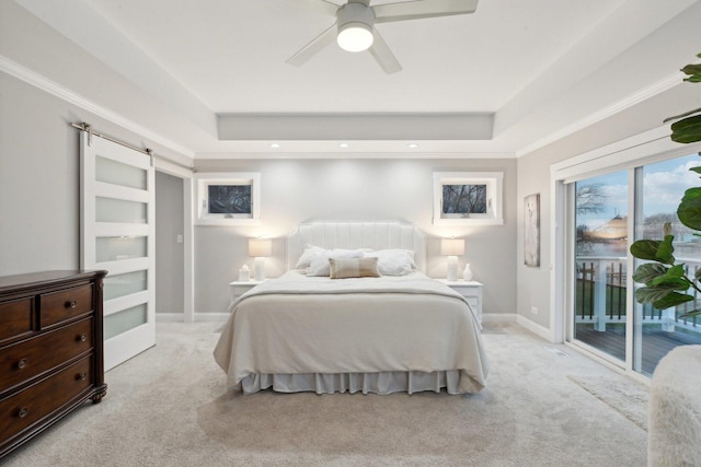 carpeted bedroom featuring ceiling fan, a barn door, a raised ceiling, and access to outside