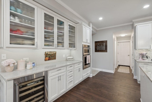 bar featuring wine cooler, light stone counters, ornamental molding, stainless steel double oven, and white cabinets