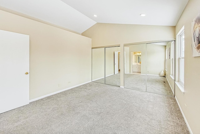 unfurnished bedroom with baseboards, carpet, vaulted ceiling, two closets, and recessed lighting