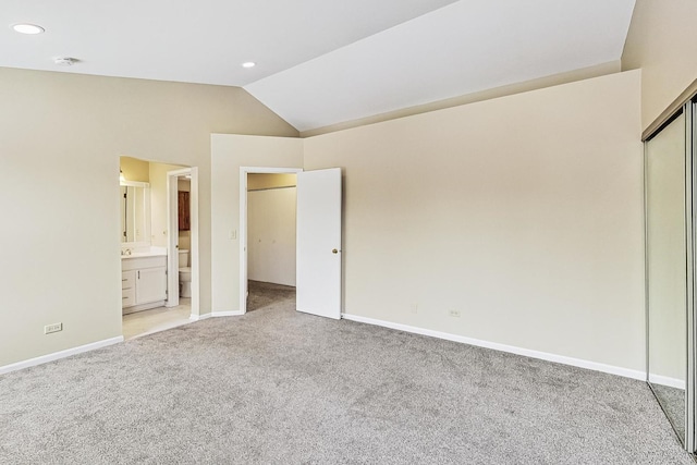 unfurnished bedroom featuring lofted ceiling, recessed lighting, light colored carpet, connected bathroom, and baseboards