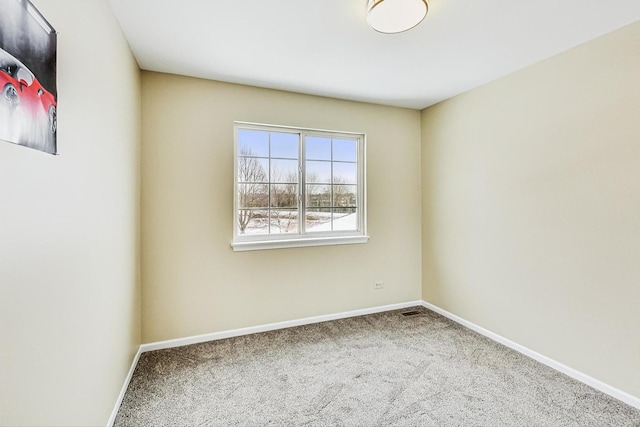 carpeted empty room featuring visible vents and baseboards