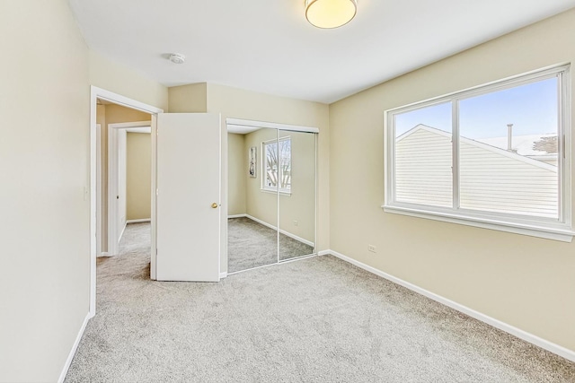 unfurnished bedroom featuring carpet, baseboards, and a closet