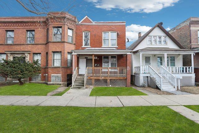 view of property with a front yard, a porch, and brick siding