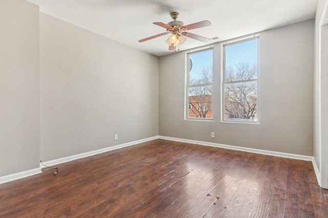 unfurnished room with a ceiling fan, dark wood-style flooring, and baseboards