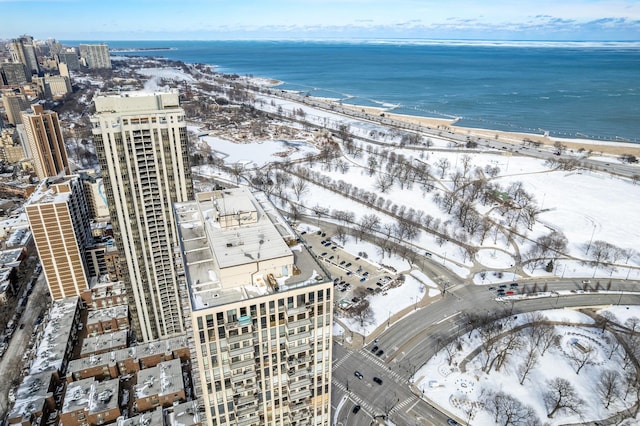 snowy aerial view with a beach view, a view of city, and a water view