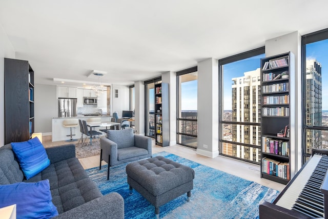 living room with light wood-style floors, floor to ceiling windows, and baseboards