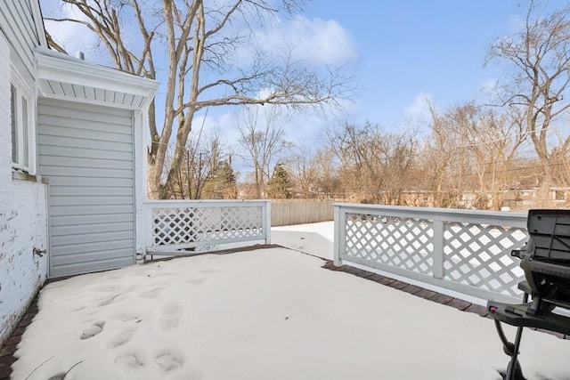 snow covered patio featuring a grill