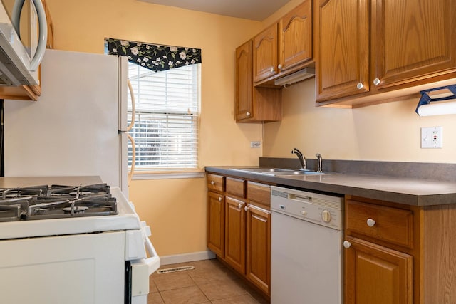 kitchen with sink, light tile patterned floors, and white appliances