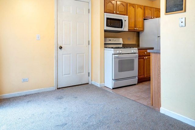 kitchen with white appliances and light colored carpet