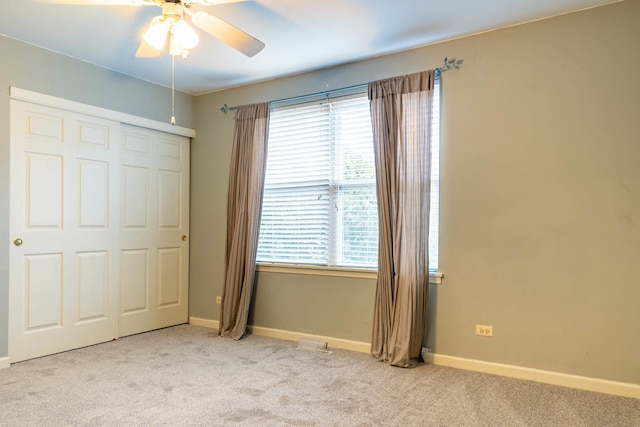 unfurnished bedroom with light carpet, ceiling fan, and a closet