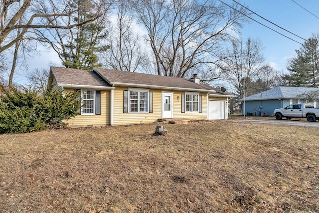 ranch-style house featuring a garage and a front lawn