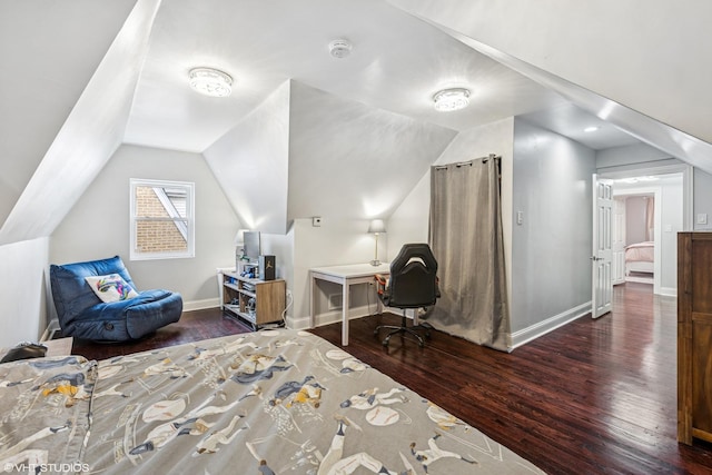 bedroom with baseboards, vaulted ceiling, and wood finished floors