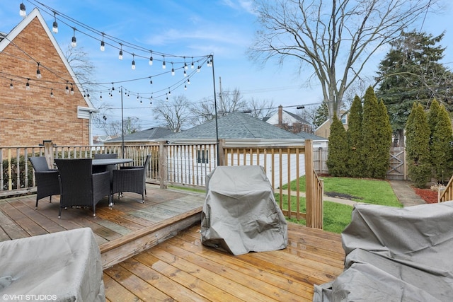 wooden deck featuring outdoor dining area, fence, and grilling area